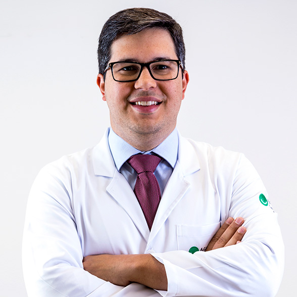 Doutor Almir Bitencourt, branco, jovem sorri de jaleco