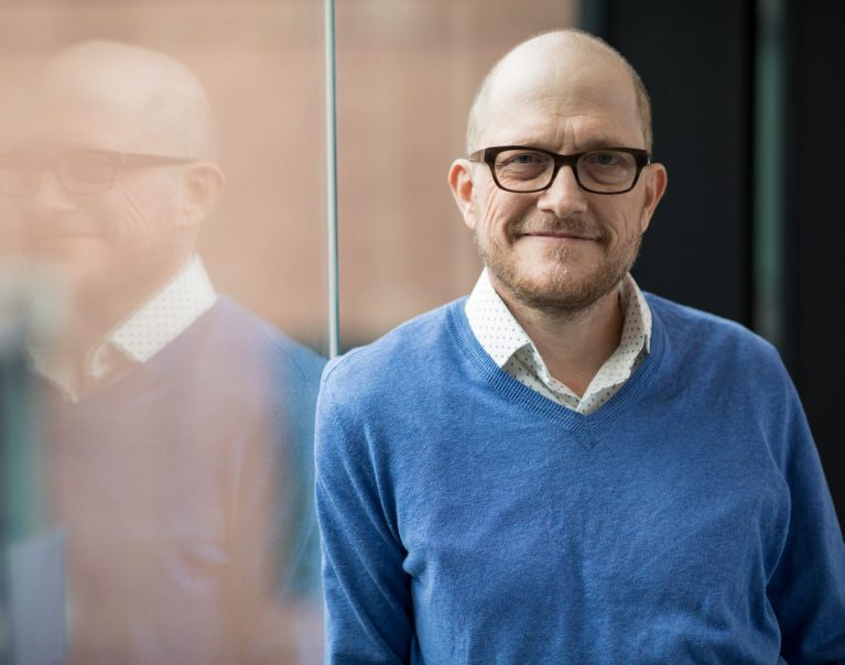 Dr. Steven Pergam, careca, loiro, de óculos e blusa de lã azul