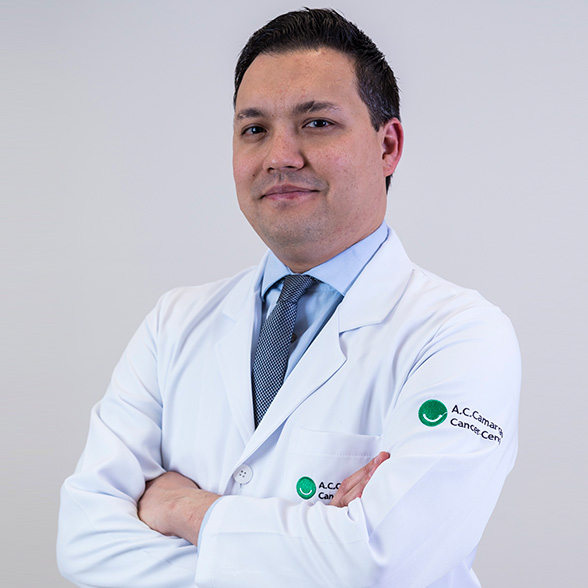 Doutor Thiago Bueno de Oliveira, branco, traços orientais, sorri de jaleco