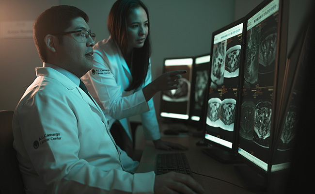 Médicos analisando imagens de exames em monitores